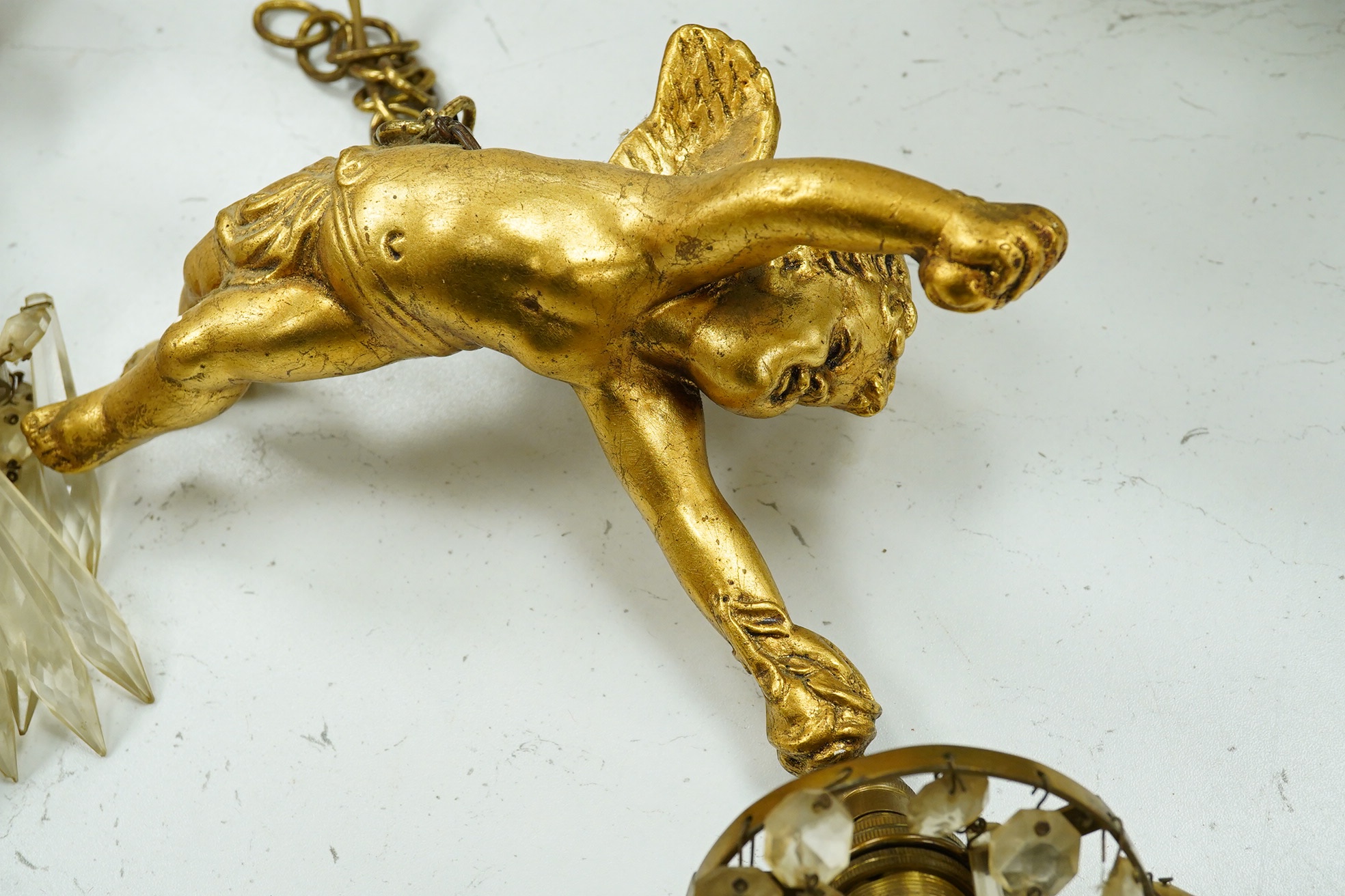 A pair of gilt plaster hanging ‘cherub’ lustre drop light fittings, 24cm long. Condition - fair to good